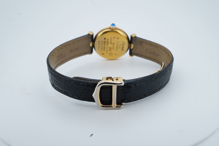 A lady's modern gilt 925 Must de Cartier quartz wrist watch, with circular Roman dial and cabochon set winding crown, case diameter 24mm, no box or papers. Condition - not running otherwise fair